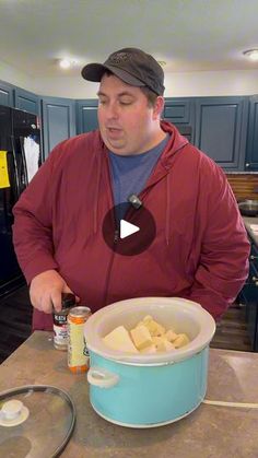 a man standing in front of a pot filled with food