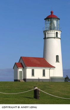 a lighthouse on top of a hill with a rope around it's perimeter and blue sky in the background