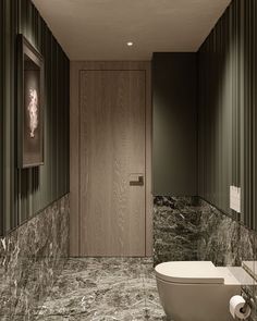 a bathroom with marble walls and flooring next to a white toilet in the corner