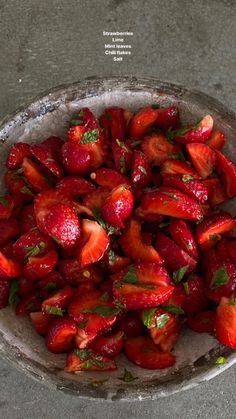 a bowl filled with sliced strawberries on top of a table