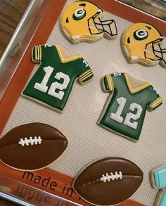 decorated cookies in the shape of footballs and helmets