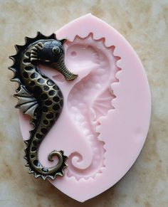 a seahorse is sitting on top of a pink mold