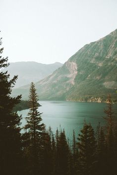 a lake surrounded by mountains and pine trees