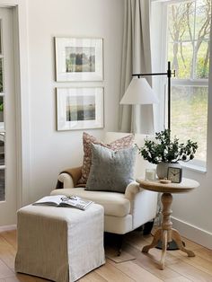 a living room with a chair, ottoman and pictures hanging on the wall above it