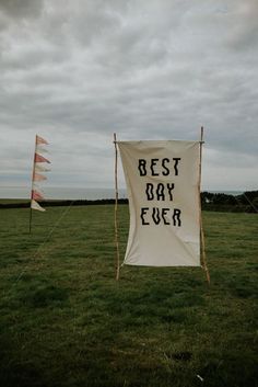 two flags with the words best day ever written on them are in an open field