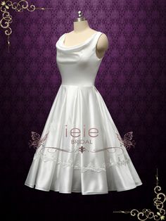 a white wedding dress on a mannequin with purple wallpaper in the background