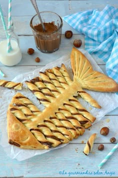 a pastry shaped like a fish sitting on top of wax paper next to some nuts