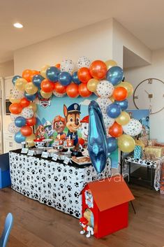 a birthday party with balloons and decorations in the shape of paw patrol, including an ice cream stand