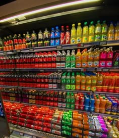 a store filled with lots of different types of sodas and juice bottles next to each other