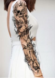 a woman's arm with flowers and skulls on it