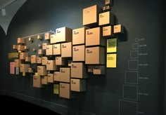 several boxes are stacked on the wall with yellow tags attached to them in order to be shipped