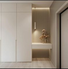 an empty room with white cupboards and wood flooring