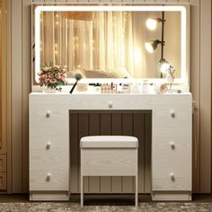 a vanity with a mirror and stool in front of it