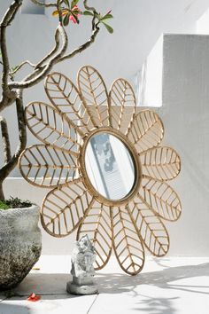 a decorative mirror sitting next to a potted plant