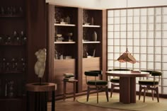 a dining room table and chairs in front of an open bookcase with glass blocks on the wall