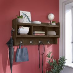 a wall mounted shelf with hooks and purses on it next to a potted plant