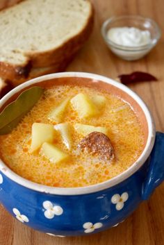 there is a bowl of soup with bread on the side