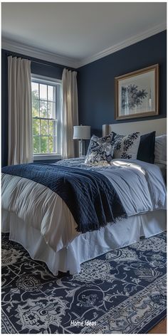 a bedroom with blue walls and white bedding in front of a window that has curtains on the windowsill