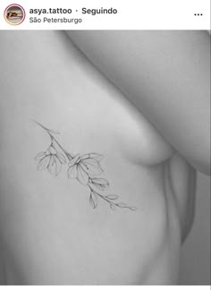 a black and white photo of a woman's breast with flowers on the side