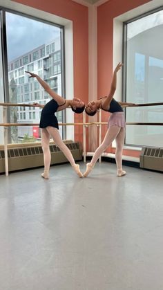 two young ballerinas practicing their moves in the ballet studio