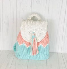 a crocheted purse with a tasselled handle