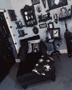 a living room filled with black furniture and pictures on the wall