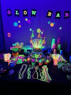 neon glow party supplies and decorations on a table