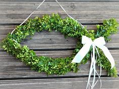 a green wreath hanging on a wooden wall