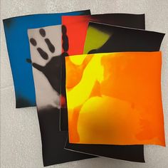 four different colored pictures on a white surface, one is black and the other is orange