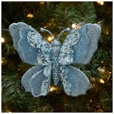 a blue butterfly ornament hanging from a christmas tree