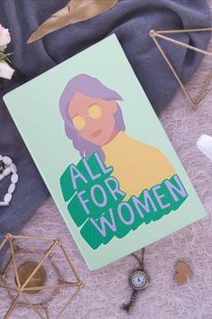 an all for women poster sitting on top of a table next to other decorations and accessories