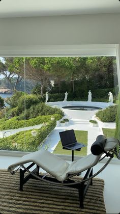 a chair sitting on top of a rug in front of a window overlooking a garden