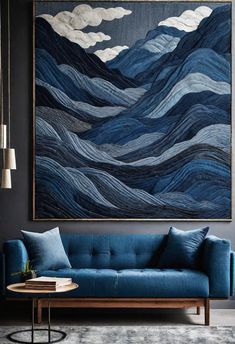 a living room with a blue couch and large painting on the wall above it's head