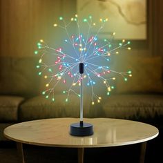 a table with a light up flower on top of it and a couch in the background