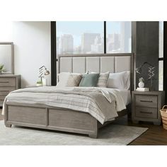 a bedroom with a bed, dressers and mirror in it's center area