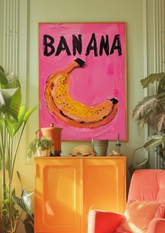 a pink painting with the word banana on it in front of a yellow cabinet and orange chair