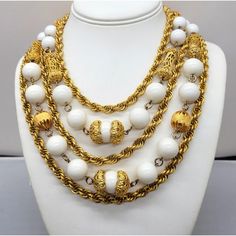 This is part of Chairish’s Costume Jewelry assortment.  1980s 5-strand goldtone 3 twisted chains with chains in between of round white resin beads and oblong filigree beads necklace with hook clasp. Marked "LES BERNARD INC." Measures: 7 1/2 inches long by 7 1/2 inches wide. Center measures: 2 inches long. Interior circumference is about 16 1/2 inches. Condition: Very good except that there is some goldtone loss around the clasp area from rubbing and a small spot of loss to the back of the clasp. White Multi-strand Beaded Chain Necklace, White Beaded Necklaces With Round Beads And Chain, Elegant White Rope Chain Necklace, Vintage Multi-strand Beaded Chain Jewelry, Vintage White Pearl Chain Jewelry, White Multi-strand Costume Jewelry Necklace, Vintage White Beaded Chain Necklace, Vintage White Necklace With Beaded Chain, Vintage Multi-strand Gold Chain Jewelry