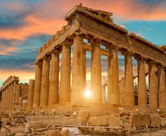 the sun shines brightly through the clouds behind an ancient temple with columns and pillars