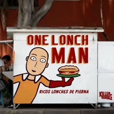 a man holding a sandwich in his hand while standing next to a sign that says one lunch man