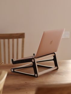 an apple laptop sitting on top of a wooden table