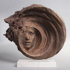 a sculpture of a woman's head with wavy hair