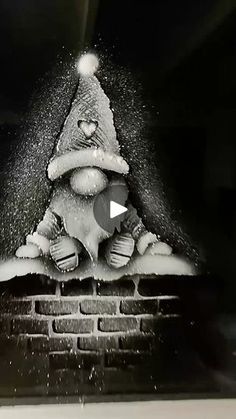 a black and white photo of a santa clause hat on top of a brick wall