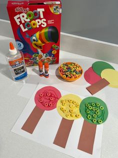 an assortment of crafting supplies sitting on top of a white table next to a box