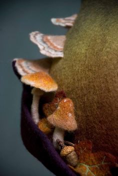 a stuffed animal with mushrooms on it's head in a purple clothed pouch