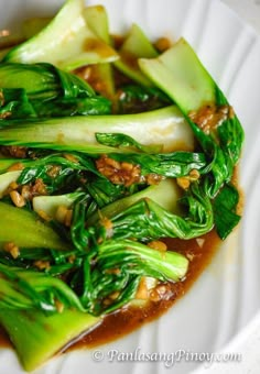 a white plate topped with broccoli covered in sauce