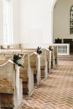 the aisle is lined with wooden pews decorated with flowers and ribbon tied to them