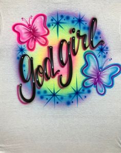 a white shirt with the words girl on it and butterflies in rainbow colors, against a white background