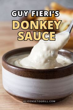 a spoon full of sauce in a bowl with the words guy fieri's donkey sauce