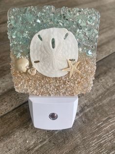 a sea urinal with shells and starfish in it on a wooden table top