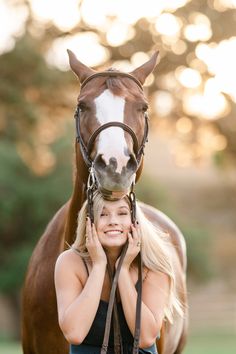 a beautiful blonde woman standing next to a brown horse